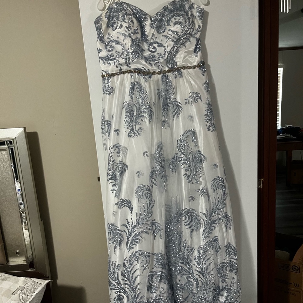 A white and sliver blue dress that is Strapless with corset like back.